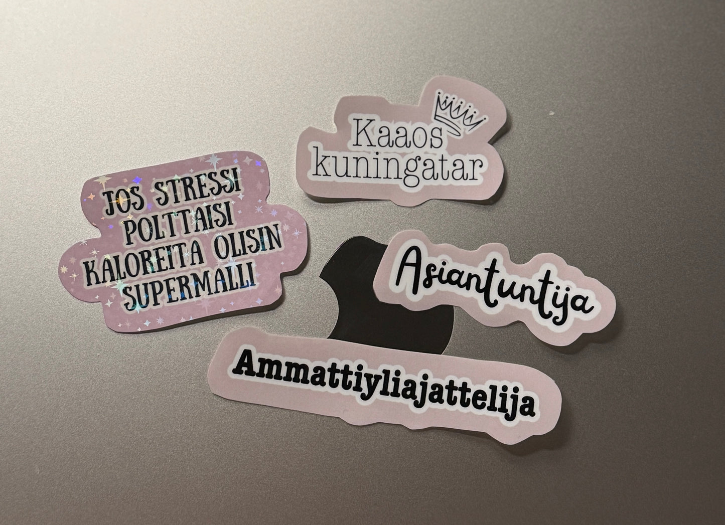 Hauska vinyylitarra läppäriin huumoritekstillä Jos stressi polttaisi kaloreita olisin supermalli, Kaaos kuningatar, Asiantuntija, Ammattiyliajattelija – Buuttipaja Kaaoskonttori