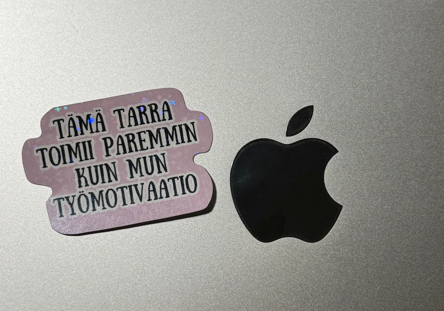 Hauska hologrammi vinyylitarra läppäriin huumoritekstillä "Tämä tarra toimii paremmin kuin mun työmotivaatio"  – Buuttipaja Kaaoskonttori