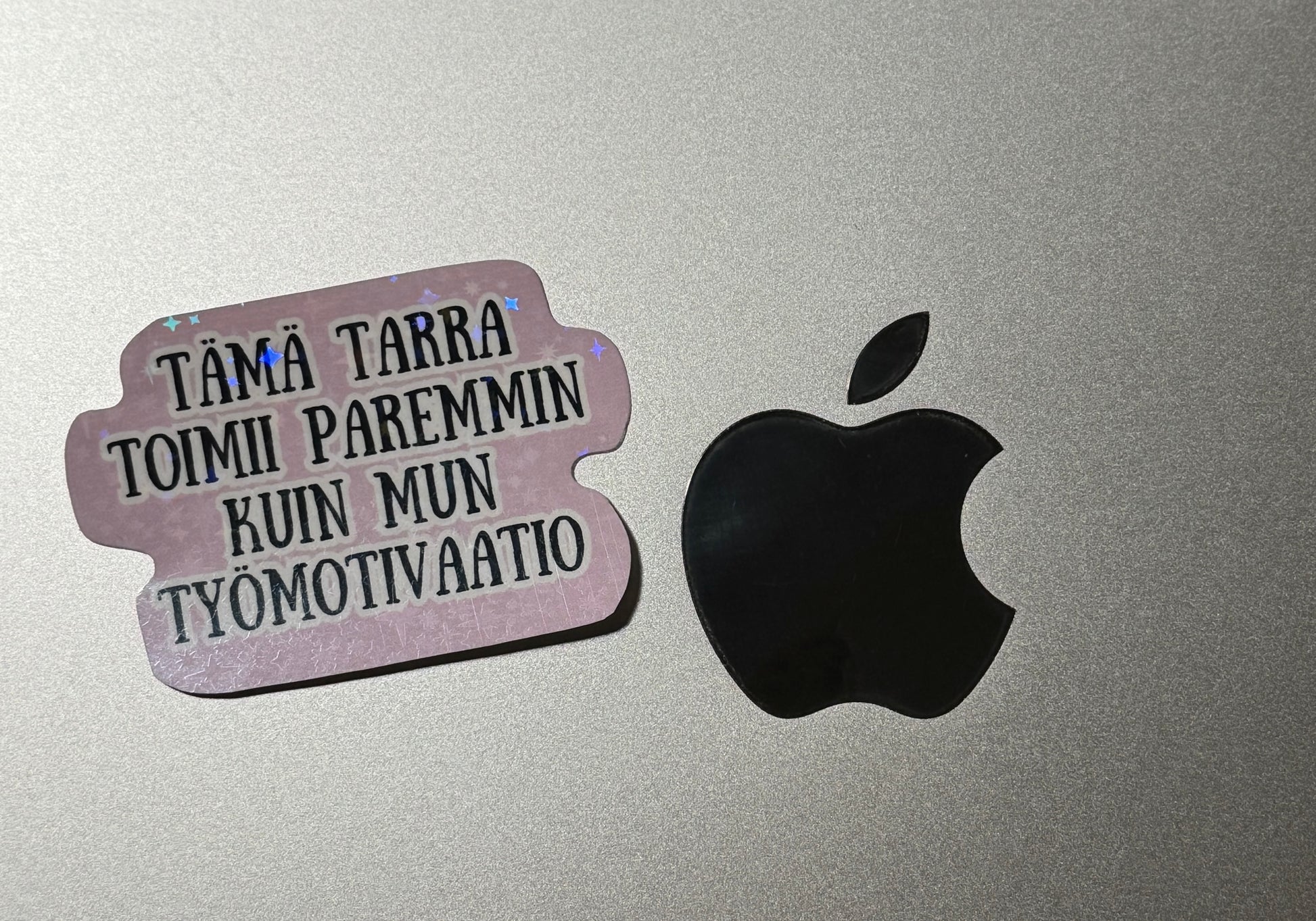 Hauska hologrammi vinyylitarra läppäriin huumoritekstillä "Tämä tarra toimii paremmin kuin mun työmotivaatio"  – Buuttipaja Kaaoskonttori
