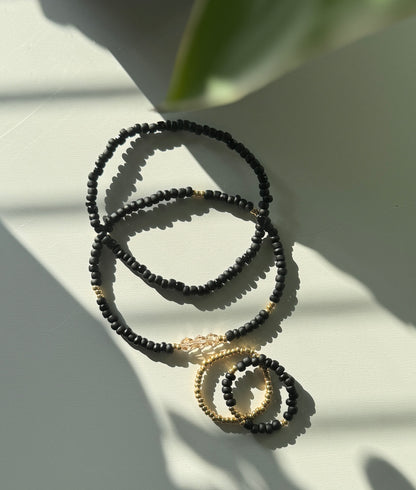 Minimal Black & Gold Stack – rannekoru- ja sormussetti (4 korua)